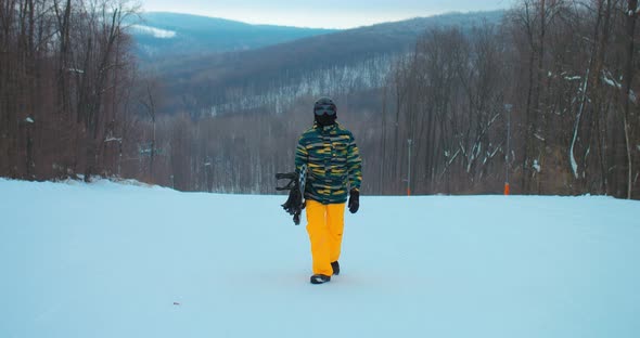 Professional Snowboarder in Safety Glasses Rises Along a Snowy Track