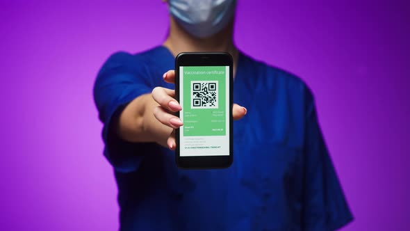 Woman Surgeon in Medical Uniform Showing Vaccination Passport with Qr Code on Phone International