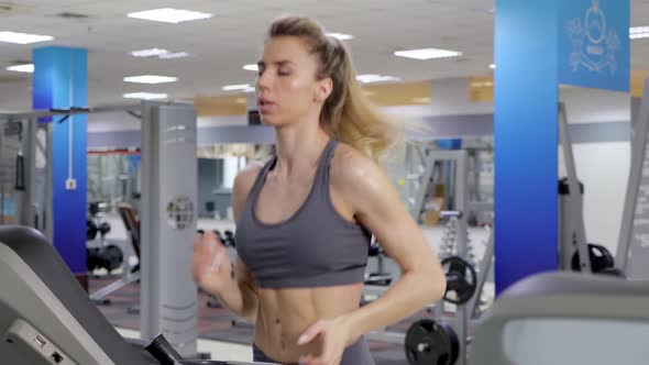 Young sporty Woman On Running Machine In Gym