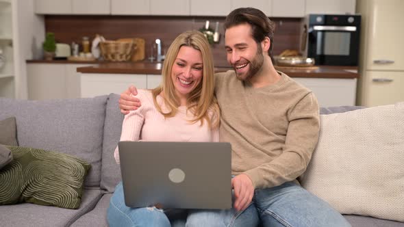 Serene Couple Spending Time Together at Home Using Laptop for Something