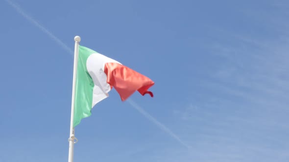 Italy flag flowing on wind in front of blue sky slow motion 1080p HD footage - Italian flag outdoor 