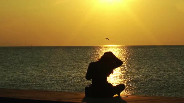 Alone Woman Sitting On Beach Thinking At Sunset