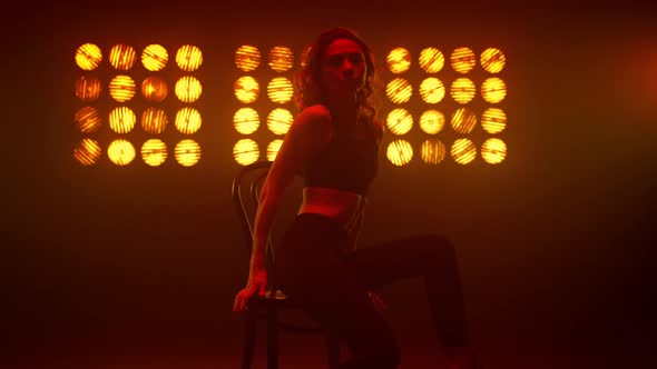 Woman Making Erotic Twine Sitting on Chair Nightclub