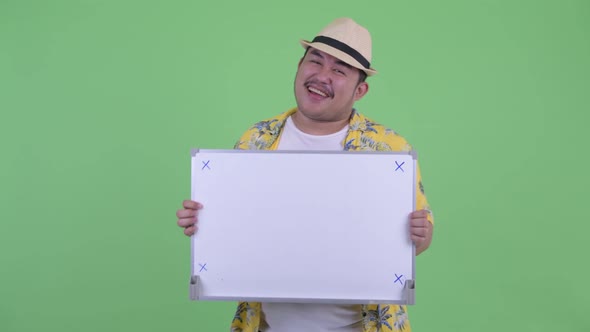 Happy Young Overweight Asian Tourist Man Dancing While Holding White Board