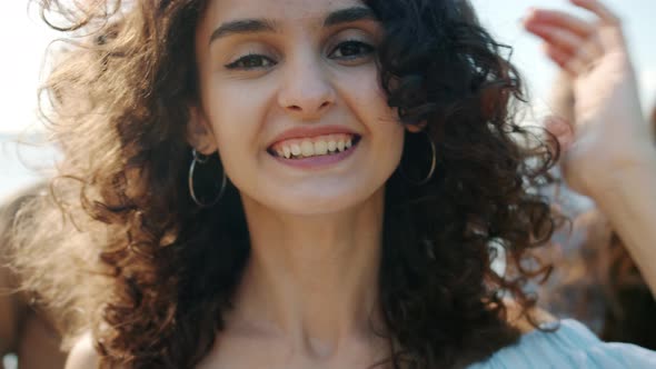 Closeup Portrait of Cute Mixed Race Lady Dancing Outdoors on Beach with Multiethnic Friends in