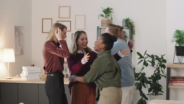 Happy Young People Greeting Each Other in Apartment
