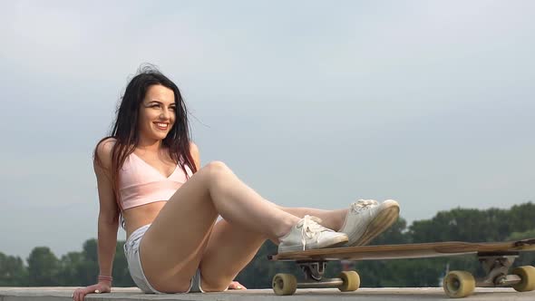 Portrait of a Hipster Young Girl Smiling with a Longboard