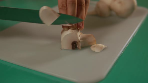 Female Using Sharp Knife To Cut Champignon