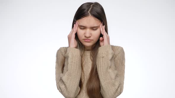 Frustrated Teenage Girl Suffering From Headache and Rubbing Her Head