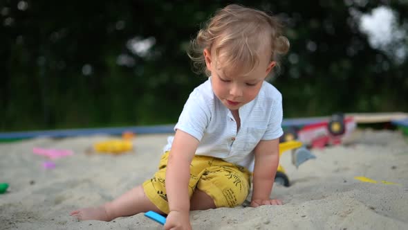 Cute Threeyearold Child is Playing in the Sandbox
