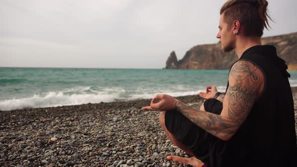 Side View of Man Sitting in Lotus Position and Meditating