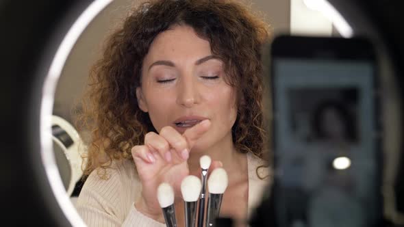Beautiful Middleaged Beauty Blogger Talks About the Types of Makeup Brushes and Their Purpose
