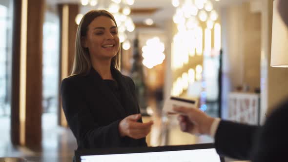Business Woman Goes to Reception of Hotel and Receives a Key Card From the Room Woman in Business