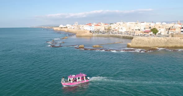 Aerial view of a passenger boat sailing near Acre old town, Israel.