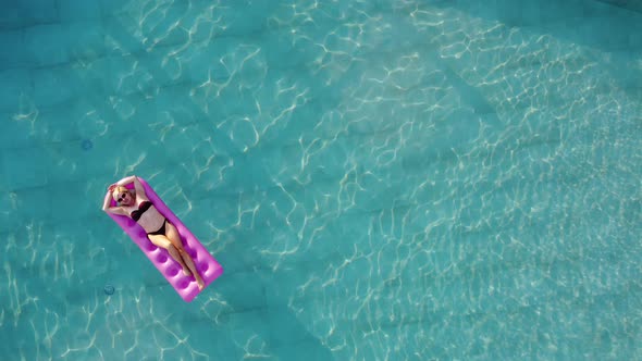 Young Pretty Woman on Air Mattress in the Pool