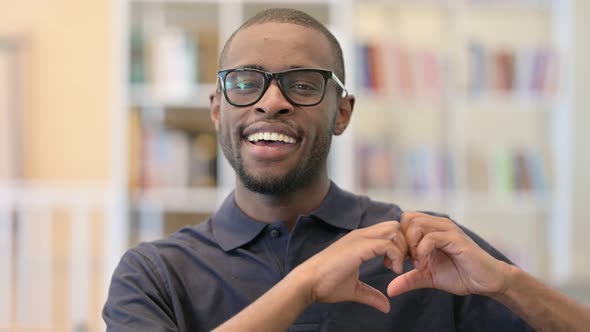 Portrait of Happy Young African Man Showing Heart Sign By Hand