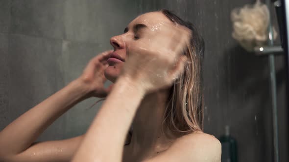 Young Blonde Woman Washing Her Hair in the Shower