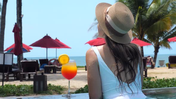 Beautiful Girl in Swimwear Drinking Colorful Yummy Cocktail at Swimming Pool