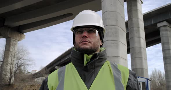 Male Contractor Looking Around Under Bridge