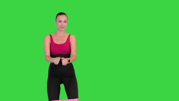 Sporty Woman Practicing Squat Exercises with Resistance Band Loop on a Green Screen Chroma Key