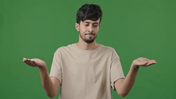 Puzzled Man Confused Uncertain Hispanic Arab Thoughtful Young Guy Standing in Green Studio Shrugs