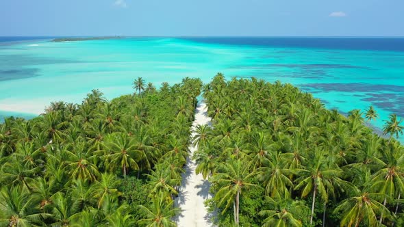 Aerial drone view landscape of idyllic tourist beach vacation by clear water with white sand backgro