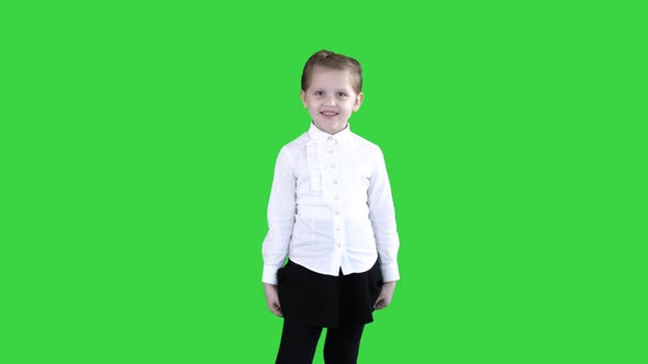 Happy Cute Little Girl Walking in the Frame and Talking To Camera on a Green Screen, Chroma Key.