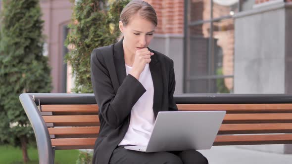 Young Businesswoman Coughing While Working on Laptop Outdoor
