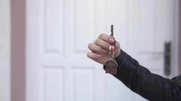 The girl holds the keys to a new apartment. The concept of buying a new apartment. Slow motion.