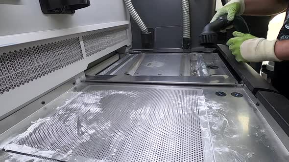 A Male Worker Cleans the Surface of an Industrial 3D Printer From White Powder