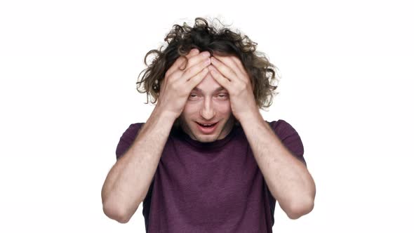 Portrait of Shocked Man with Curly Hair in Casual Tshirt Covering Face in Surprise and Expressing