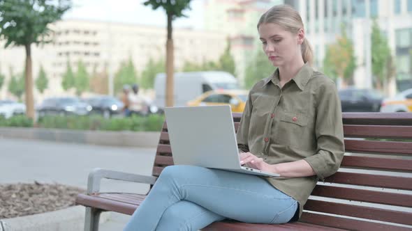 Busy Woman Using Laptop Sitting Outdoor on Bench