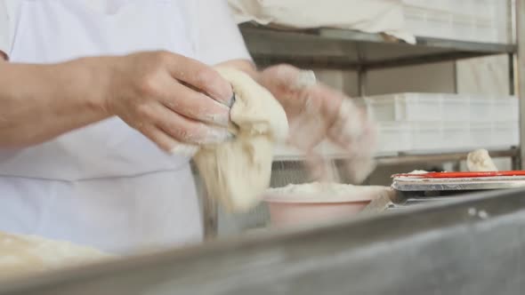 the Female Hands of the Baker Form a Round Bun From the Dough for Baking in the Oven