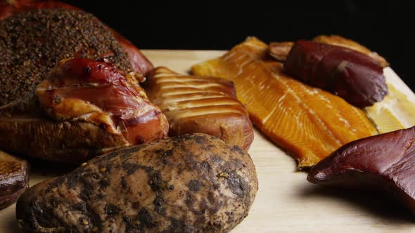 Rotating shot of a variety of delicious, premium smoked meats on a wooden cutting board - FOOD 055