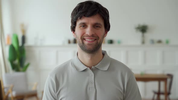 Portrait of a Happy Man in a Gray Shirt Looking at the Camera and Smiling