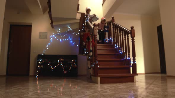 Cheerful Kids Carrying Presents Downstairs.