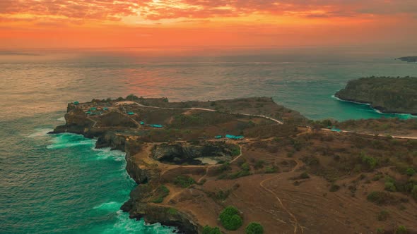 Sunset at Rocky Coastline Broken Beach and Stone Arch Over the Sea in Nusa Penida, Bali, Indonesia