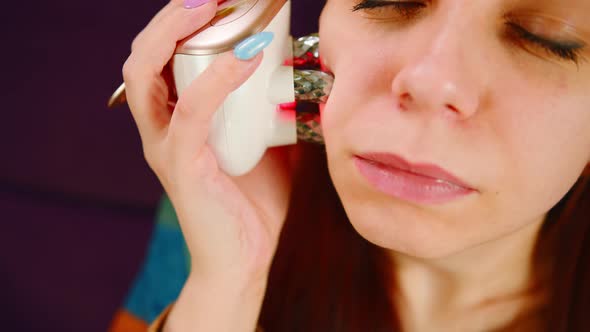 A Relaxed Woman Using Face Electric Massager