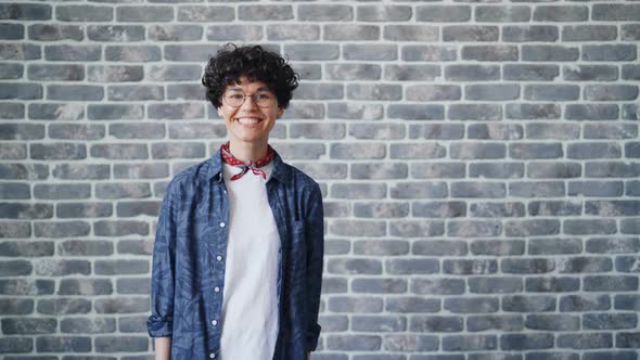 Portrait of Girl Turning Looking at Camera with Happy Smile on Brick Background