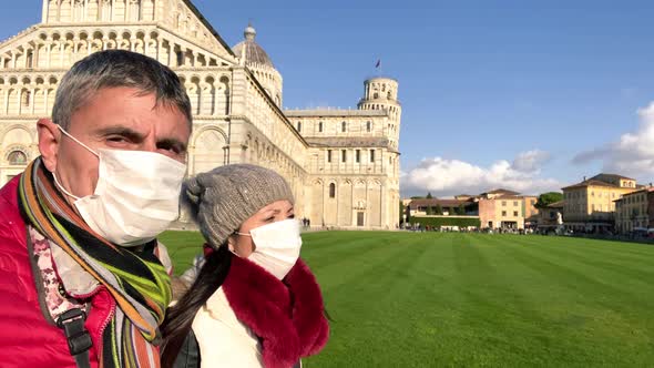 Couple Talking Outdoor with Face Masks in Front of a Landmark