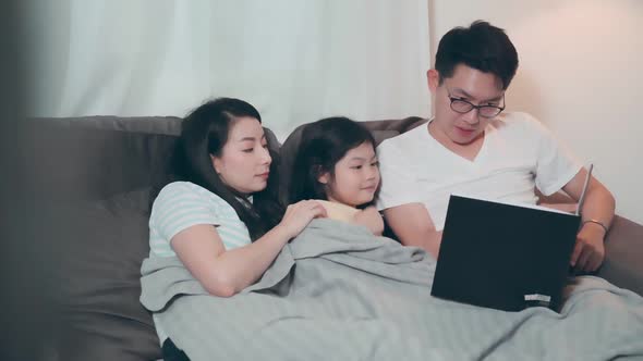 young attractive asian mom reading Children's stories to pretty cute daughter child