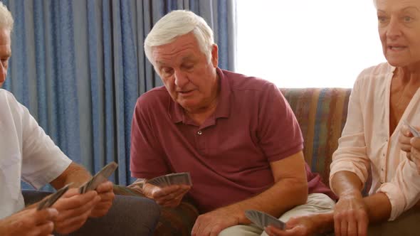 Group of senior friends playing cards