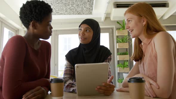 Young adult female friends hanging out in a cafe