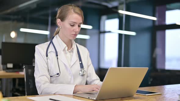 Ambitious Young Female Doctor Working on Laptop in Office