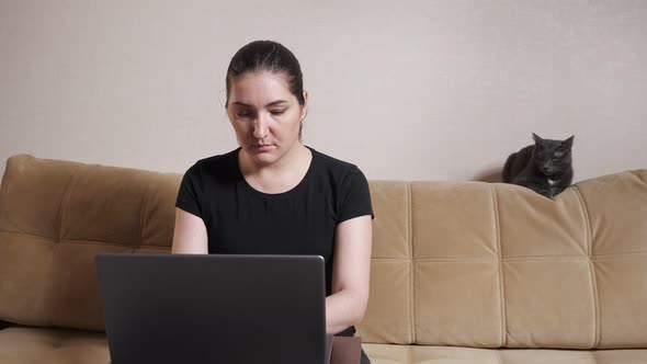 Brunette with Ponytail Looks Into Laptop Display at Home