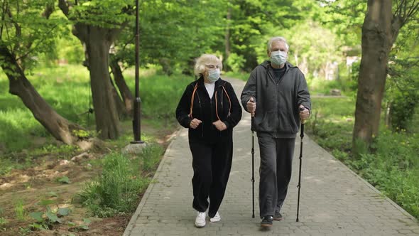 Active Senior Old Man, Woman Training Nordic Walking in Park During Quarantine