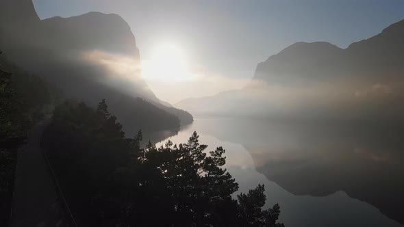 Gorgeous Morning in Norwegian Nature. Flying Over Silhouette of Mountains, Trees and Fjord. Aerial