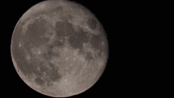 Jet Plane Crossing the Moon at Night with Trail