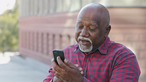 Kind Calm Senior Black Grandfather Makes Video Call Looks at Smartphone Camera African American