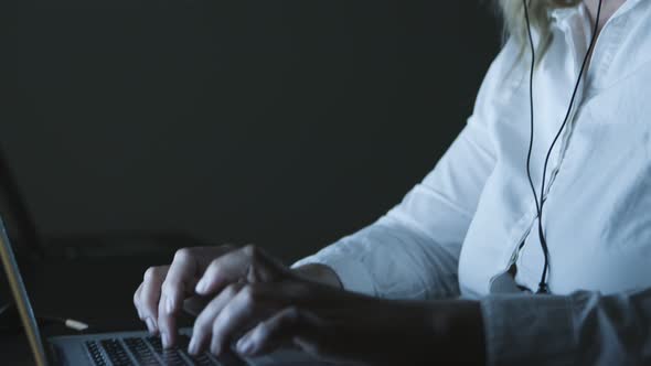 Focused Businesswoman in Headset Using Laptop